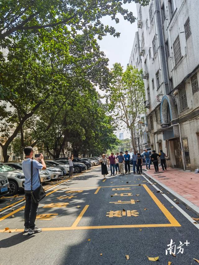 考评人员在小区内验收小区道路改造情况。唐梦 摄