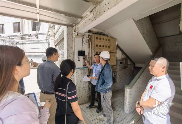 考评人员在改造小区内检查可视门铃安装设备。唐梦 摄