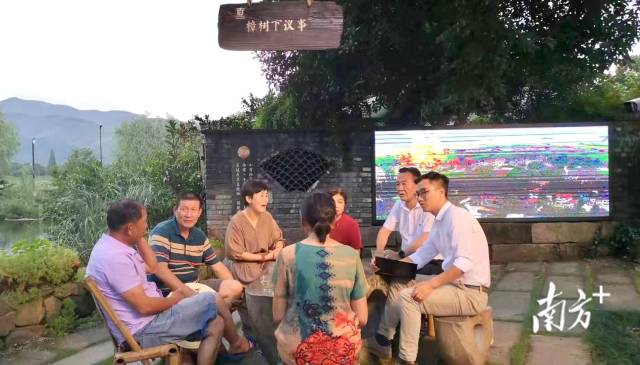 小古城村村民与村干部正在樟树下议事。